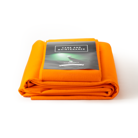 Hainsworth-SMART Orange folded pool table cloth with a care and maintenance label on a white background
