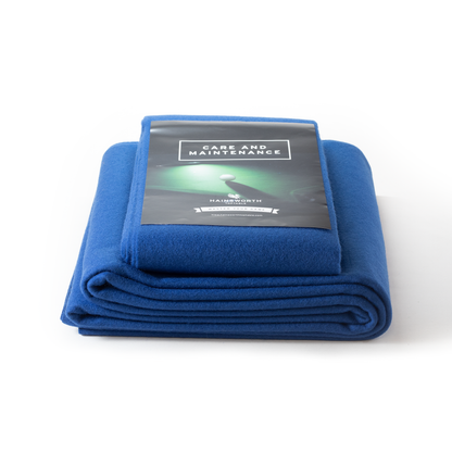 Folded Hainsworth blue pool table cover with a care and maintenance card on a white background